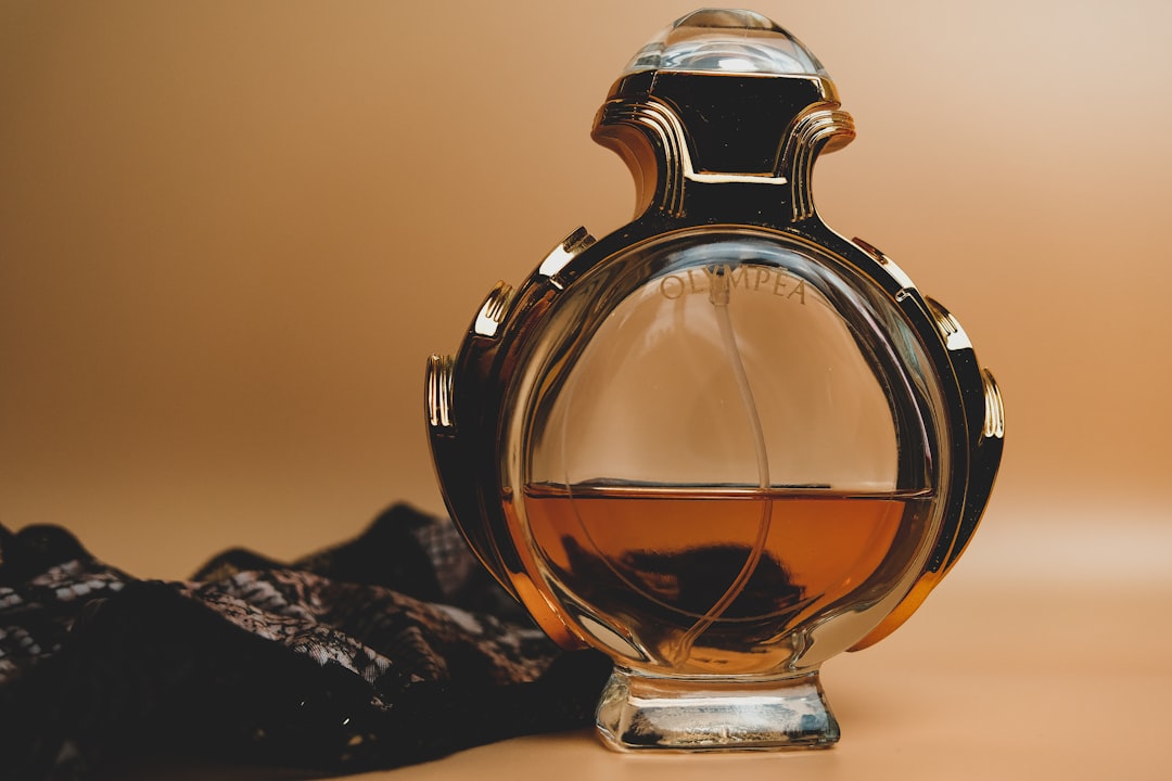 Amber perfume bottle with gold filigree against velvet